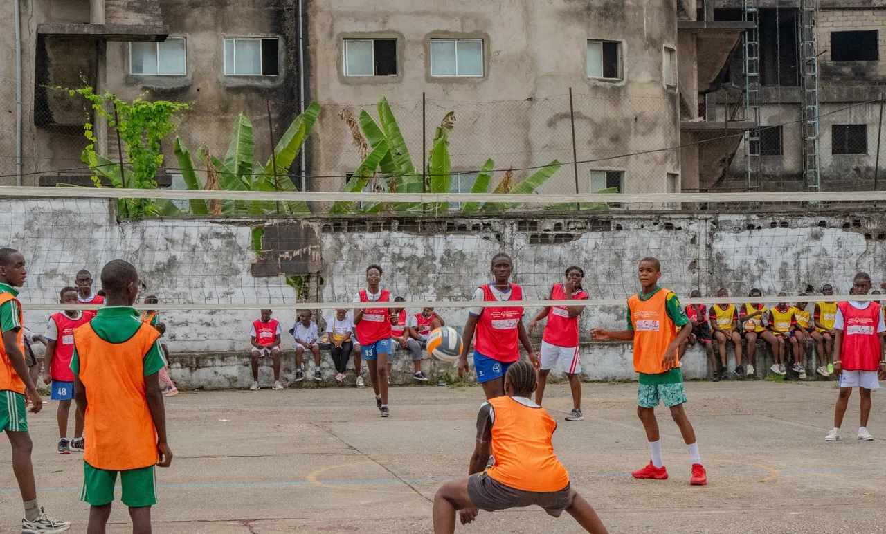 Match de volleyball entre équipes en chasubles sur un terrain scolaire