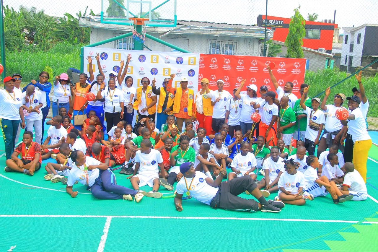 Grande photo de groupe de jeunes athlètes médaillés et d’adultes sur un terrain multisport