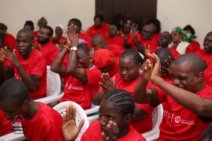 Participants en tee-shirts rouges applaudissant dans une salle