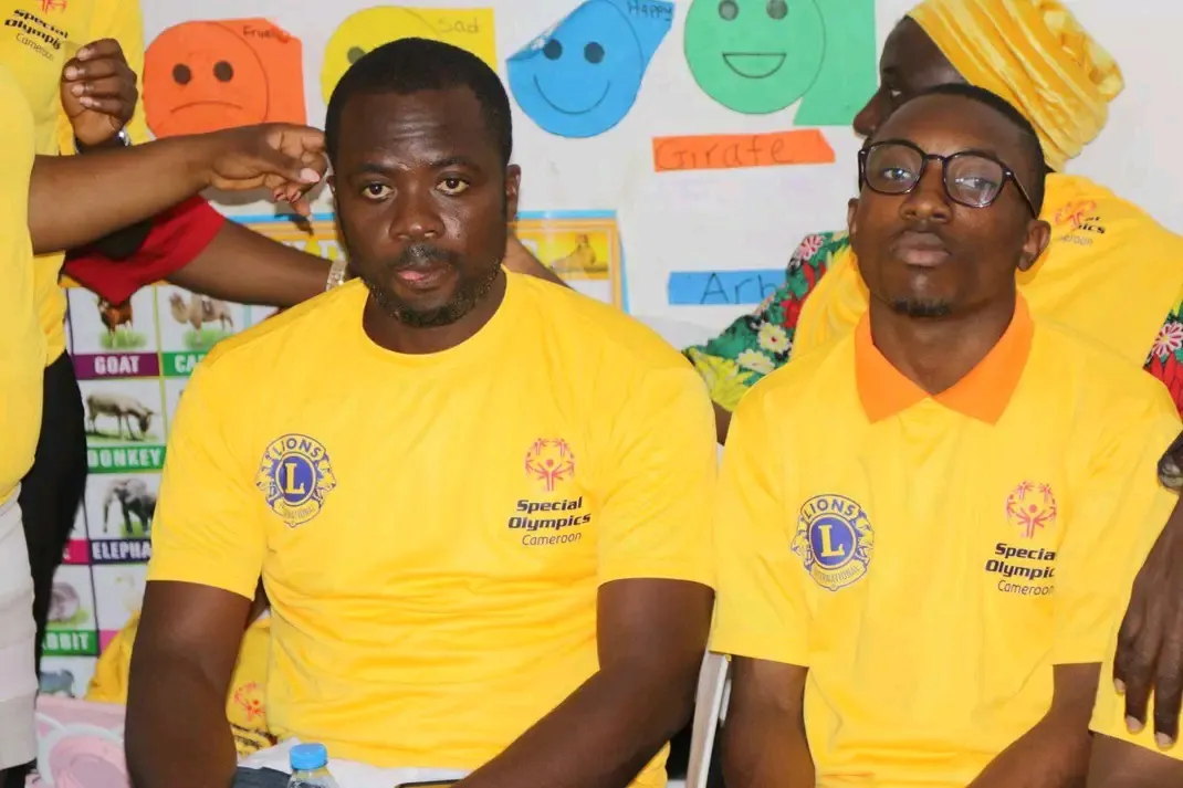 Deux participants en tee-shirts jaunes aux couleurs de Special Olympics Cameroun dans une salle de classe