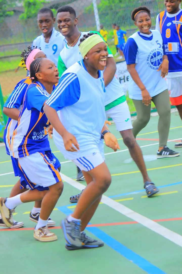 Jeunes basketteuses riant ensemble sur le terrain